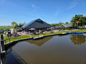 a large building with boats in a body of water at Tsjirk in Sprong