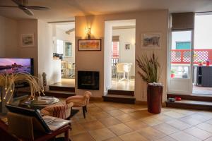a living room with a fireplace and a tv at Hotel Les Almadies - Coeur de Ville in Saint-Jean-de-Luz