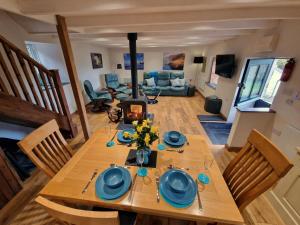 a dining room with a table and a fireplace at Ponycob hot tub 2 bed ensuite in Llwyn-Dafydd