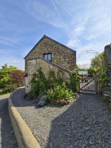 a brick building with a window and a fence at Ponycob hot tub 2 bed ensuite in Llwyn-Dafydd