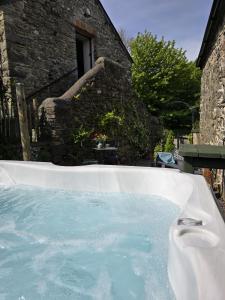a jacuzzi tub in front of a house at Ponycob hot tub 2 bed ensuite in Llwyn-Dafydd