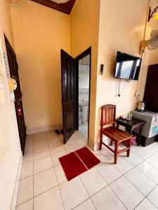 a room with a toilet and a television and a chair at Camellia Hotel in Vang Vieng