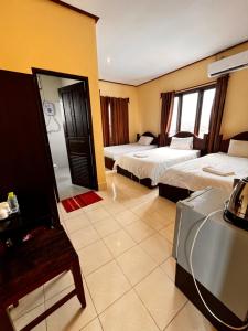 a hotel room with two beds and a mirror at Camellia Hotel in Vang Vieng