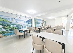 a dining room with tables and chairs and posters at Ucha Hotel & Suites in Kampala