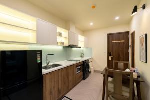 a kitchen with a sink and a black refrigerator at Weal Apartment in Danang