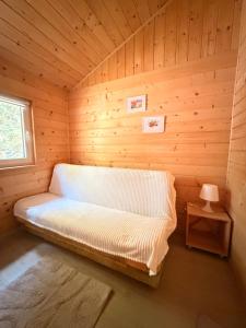a room with a bed in a wooden room at Domki nad Firlejem in Firlej