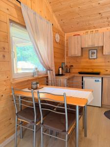 a kitchen with a table and chairs in a cabin at Domki nad Firlejem in Firlej