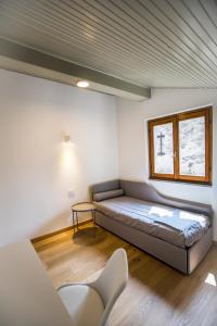 a bed in a room with a window and a couch at La Ca di Nosee in Nesso