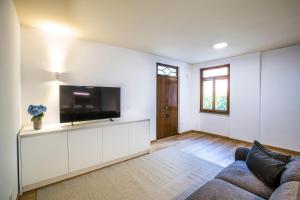 a living room with a couch and a flat screen tv at La Ca di Nosee in Nesso