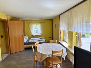 a room with a table and chairs and a bed at Möllers Morgen in Lentföhrden