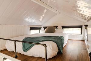 a bed in the middle of a room in a trailer at Odyssean Tiny House A by Tiny Away in Cessnock