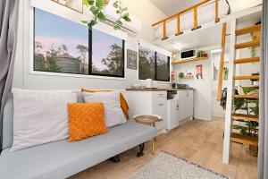 a living room with a couch in a tiny house at Yellow Rock Views by Tiny Away in Broke