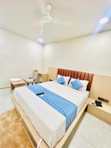 a bedroom with a large bed with blue pillows at Hotel Sulin Prahladnagar in Ahmedabad