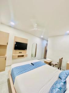 a bedroom with a large bed and a flat screen tv at Hotel Sulin Prahladnagar in Ahmedabad +18 photos
