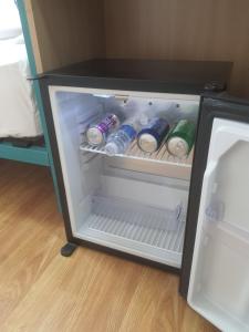 an open refrigerator with bottles of water in it at Oxygen Village in Zeïda