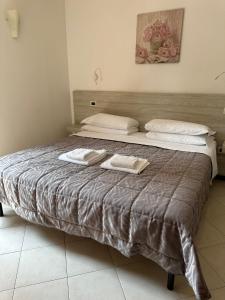 a large bed with two towels on top of it at Le Corti Del Lago in Padenghe sul Garda +30 photos