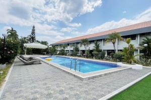 a swimming pool in front of a building at Maharajah Hotel Angeles City in Angeles +19 photos