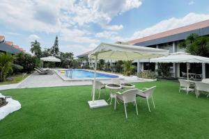 a patio with a table and chairs and a pool at Maharajah Hotel Angeles City in Angeles