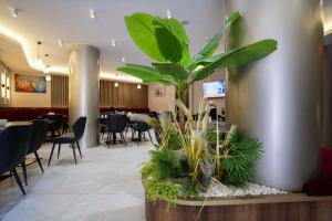 ein Restaurant mit einer Pflanze mitten in der Lobby in der Unterkunft Ugurlu Hotel in Gaziantep