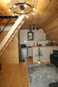 a living room and kitchen with a staircase in a cabin at LUNEA cottage in Machakhlispiri +8 photos