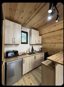 a kitchen with wooden cabinetry and a counter top at LUNEA cottage in Machakhlispiri