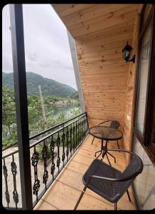 a balcony with a table and chairs and a view at LUNEA cottage in Machakhlispiri