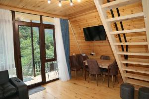 a dining room with a table and a large window at LUNEA cottage in Machakhlispiri