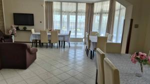 a dining room with tables and chairs and a tv at Horgász-Vadász Vendégház in Egyek
