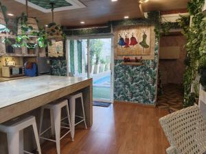 a kitchen with a large counter with stools and a large window at Charming House with Private Pool in Bacolod +15 photos