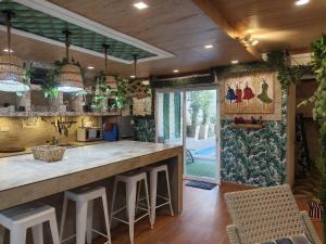 a kitchen with a large counter with stools in it at Charming House with Private Pool in Bacolod