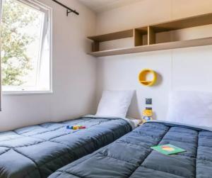 two beds in a small room with a window at Cottage PARKS OLVA in Sartène