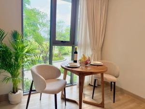 a dining room table with two chairs and a bottle of wine at Skypark Laguna Phuket by Escape Villas in Laguna Phuket