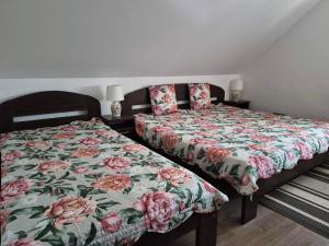 a bedroom with two beds with a floral bedspread at Horgász-Vadász Vendégház in Egyek