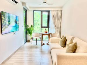 a living room with a couch and a table at Skypark Laguna Phuket by Escape Villas in Laguna Phuket