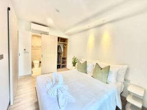 a bedroom with a white bed with a towel on it at Skypark Laguna Phuket by Escape Villas in Laguna Phuket