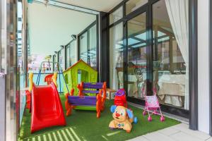 a play area with colorful playground equipment in front of a building at Hotel De Londres in Riccione