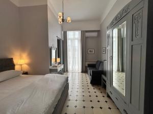 a bedroom with a bed and a living room at Tinion Hotel in Tinos