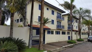 a building with blue shuttered windows and palm trees at Acarau Unidade 15 in Ubatuba
