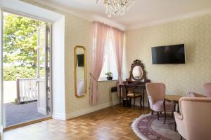 a living room with a table and a mirror at Kastanjelund in Yngsjö