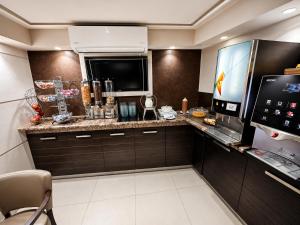 a kitchen with a counter with a microwave and a tv at Epidavros Hotel in Athens