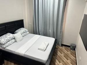 a bedroom with a bed with a book on it at Gekamo Suites in Dar es Salaam +2 photos