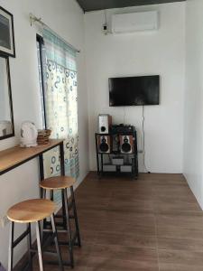a living room with two stools and a flat screen tv at Solaya Cove Private Resort in Bansud