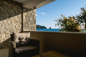 a chair in a room with a view of the ocean at Black Rocks Family Beach Resort in Agios Gordios