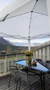 a table and chairs on a deck with an umbrella at Hilltop wood house #1 all-inclusive in Kaupanger