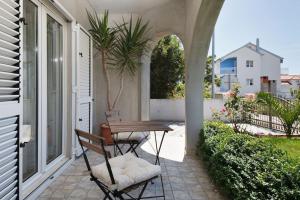 a patio with a table and chairs on a porch at Black and White Spacious Apartment in Hvar