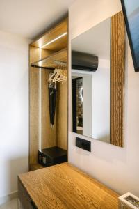 a dressing room with a mirror and a wooden cabinet at Black Rocks Family Beach Resort in Agios Gordios