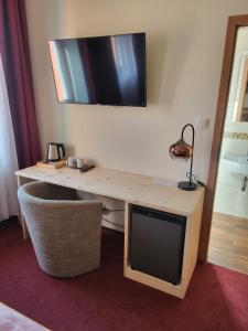 a desk with a television on a wall at Pension U Koupaliště in Tisá