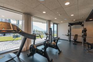 a gym with tread machines and a large window at Hotel Schlosswirt in Schenna