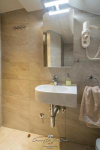 a bathroom with a white sink and a mirror at Charming old stone house in Sali +30 photos
