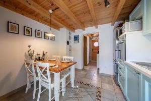 a kitchen and dining room with a wooden table and chairs at Charming old stone house in Sali